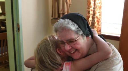 Sister Mary Marguerite says goodbye to one of the children  at the last public mass held on on Sunday, Aug, 11 2019, at the Monastery of St Clare in Memphis. The nuns will be leaving the building that has housed their order since 1932 in the Frayser neighborhood. Their numbers have dwindled down to four sisters. In May of 2018 the Vatican issued guidelines that all contemplative communities should have at least seven members. The monastery will be closed at the end of the year. (Photo by © Karen Pulfer Focht)